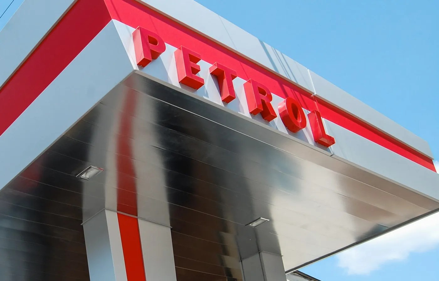 Red dimensional letters spell a name along the edge of a metal canopy.