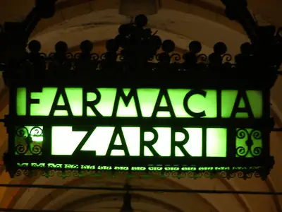 A lit glow sign board hangs outside a shop.