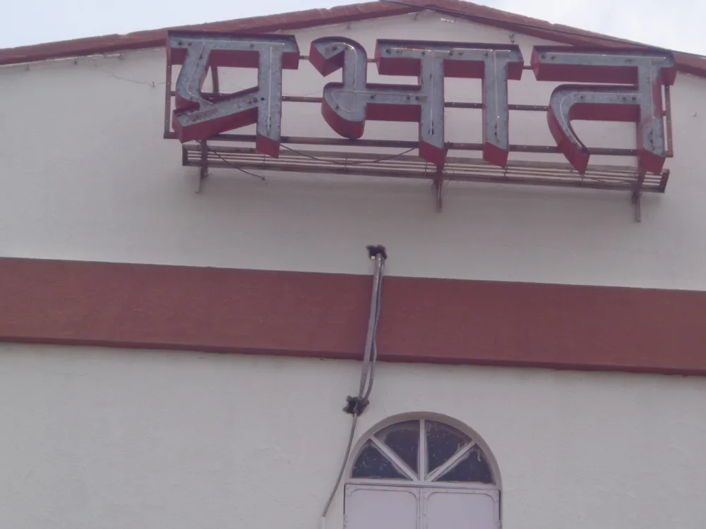 Prabhat cinema letters in Pune with a loose cable under the sign that needs repair.