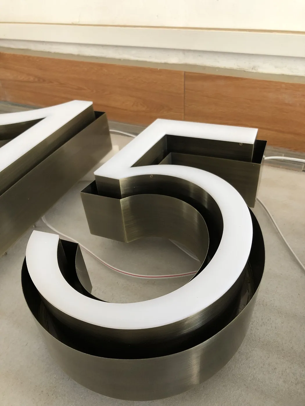 Brushed metal channel letters with pale acrylic faces.